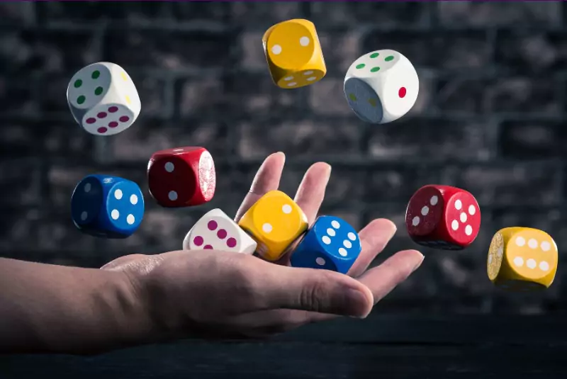 a person holding ludo dice in hand